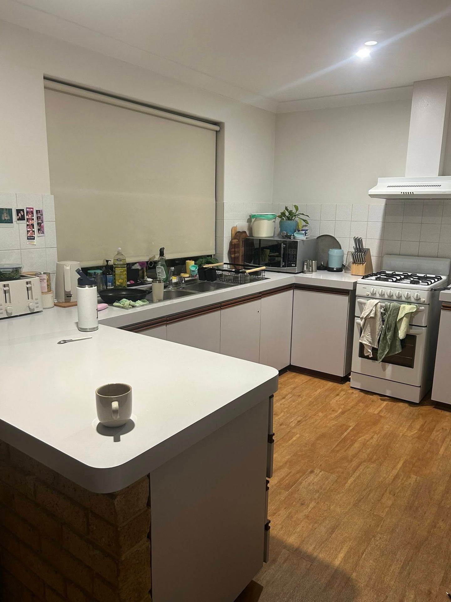 Before photo — Kitchen reset in a Rockingham family home — benches, sink, and stovetop area cleared and wiped down. in Rockingham
